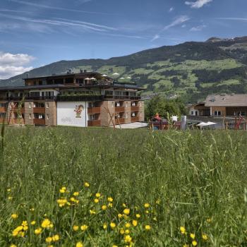 Wunderbar ist das Haus in die Landschaft eingefügt - Kinderhotel mit Lifestyle „alpina zillertal“ in Fügen